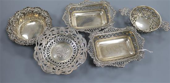 A pair of George V pierced silver bonbon dishes, two other pierced dishes and a pierced silver quaich by William Comyns.